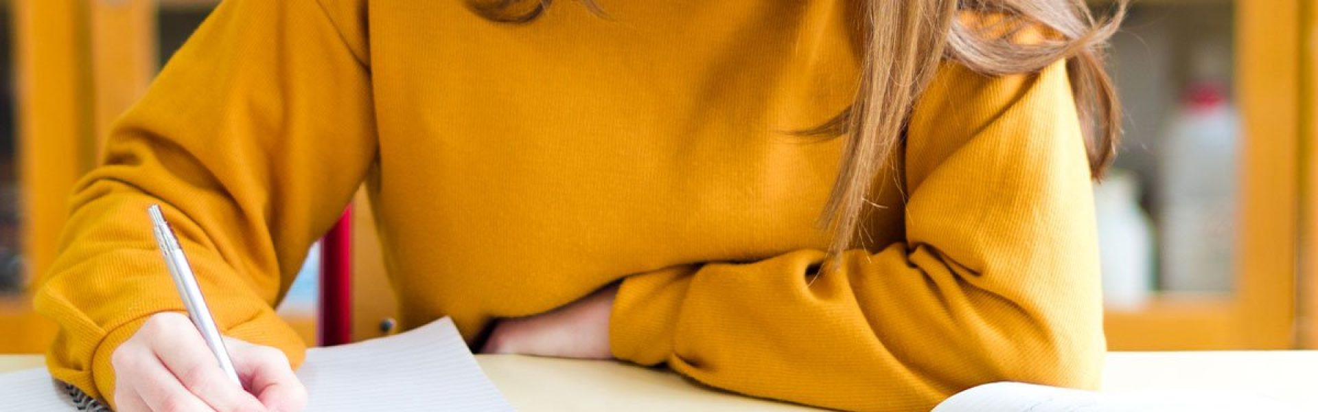 Student in yellow sweater taking notes