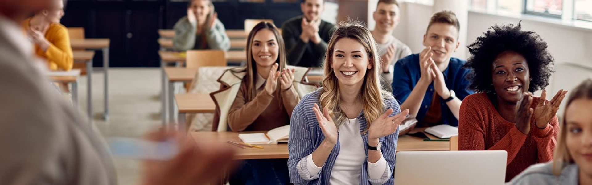 Students applauding teacher in classroom